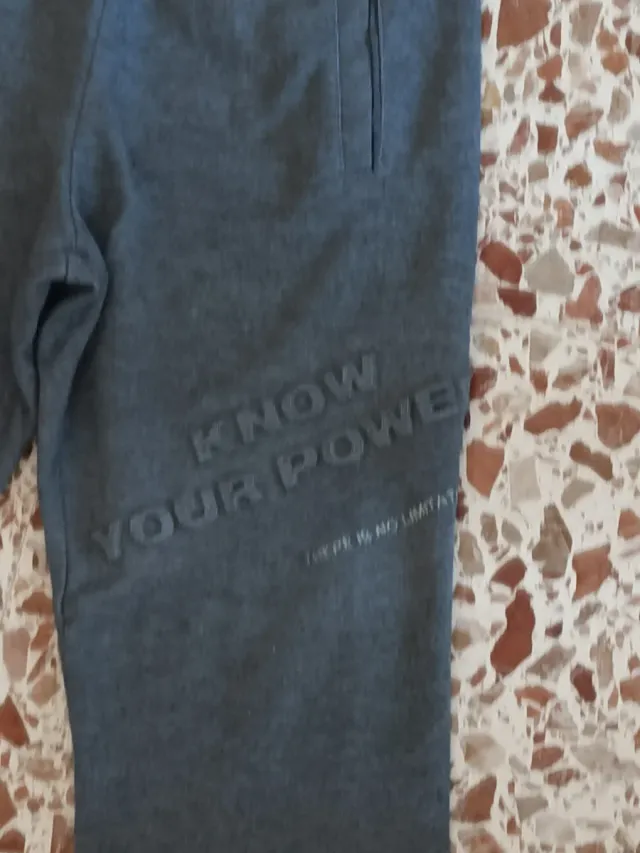 Pantalones grises con mensaje de zara