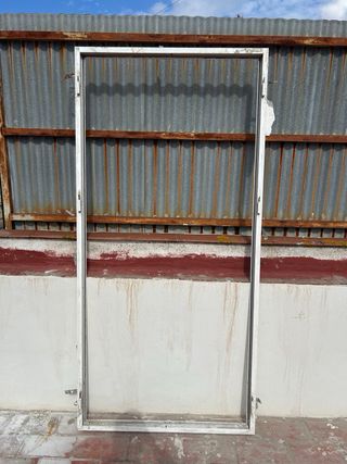 Puerta doble de aluminio con reja y premarco