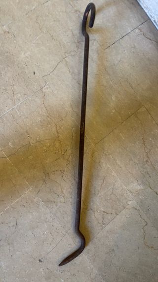 Antico gancio per camino in ferro