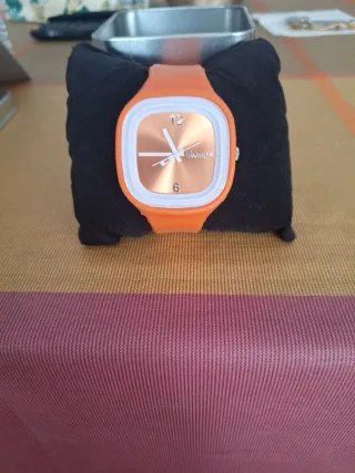 Reloj de pulsera naranja y dorado