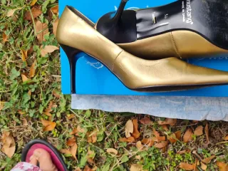 Zapatos de tacón dorados para mujer con bolso.