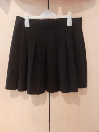 Falda negra de pliegues