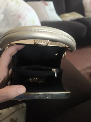 Bolso rígido dorado cara mujer gafas rojas