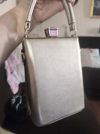 Bolso rígido dorado cara mujer gafas rojas