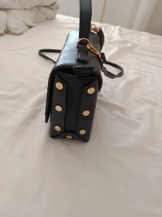 Bolso negro con tachas doradas