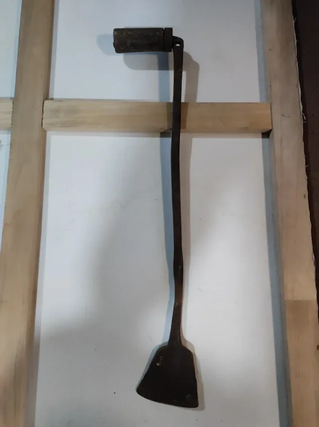 Herramienta antigua de metal con mango de madera