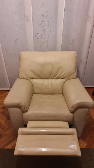 Sofá reclinable de piel beige.