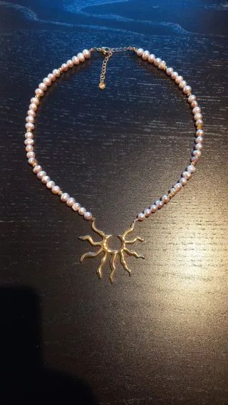 Collar de cuencas perladas y doradas y sol dorado.
