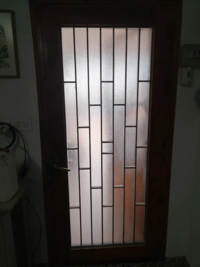 Puerta de entrada de madera con reja