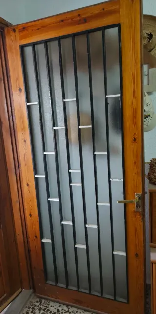 Puerta de entrada de madera con reja