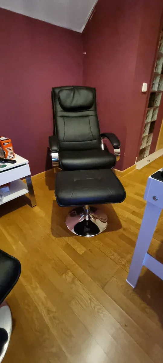 2 Sillones de piel negro con reposapiés.