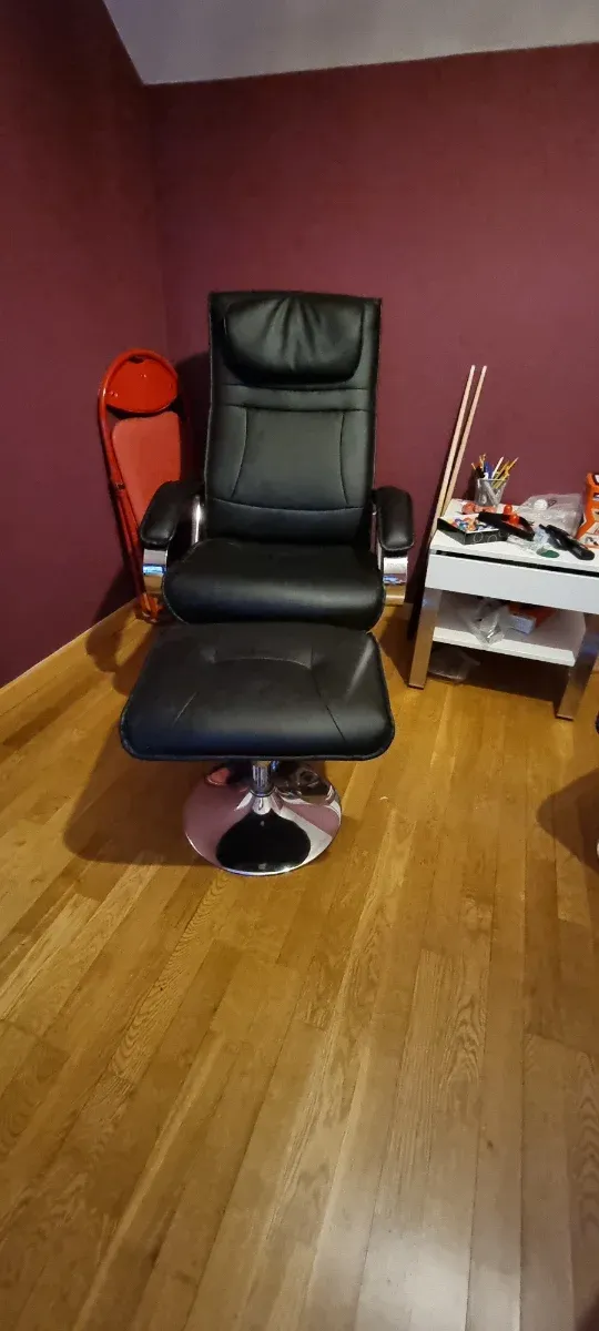 2 Sillones de piel negro con reposapiés.