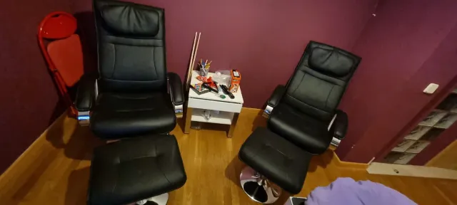 2 Sillones de piel negro con reposapiés.