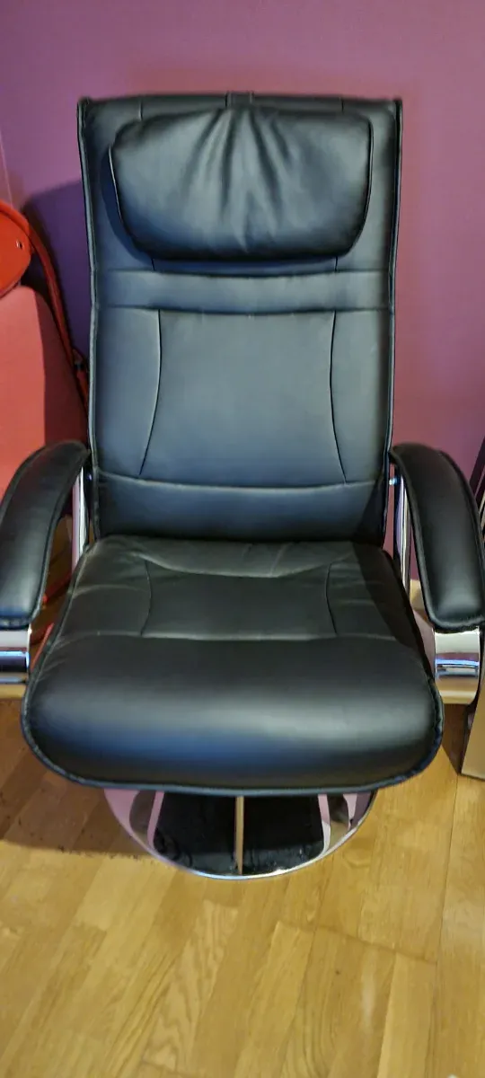 2 Sillones de piel negro con reposapiés.