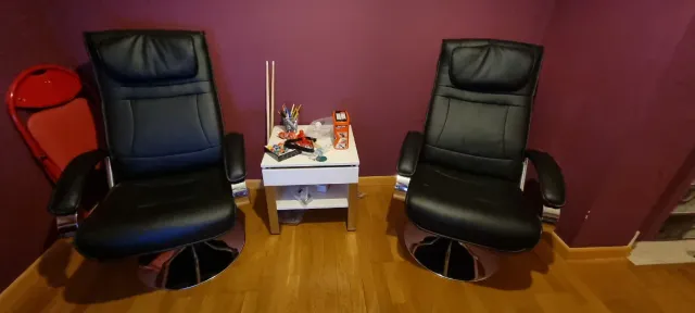 2 Sillones de piel negro con reposapiés.