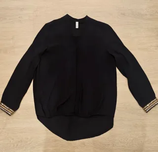 Blusa negra con detalles dorados. Talla S