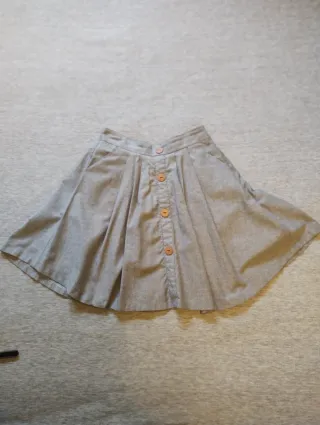 Falda corta talla M, con vuelo, bolsillos y botone