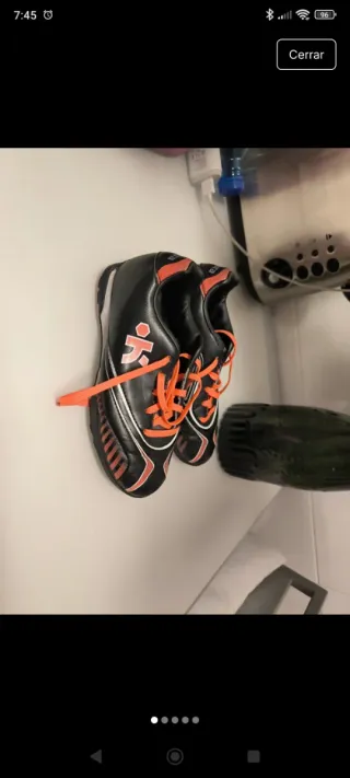 Botas de fútbol multitacos negras y naranjas