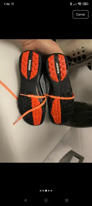 Botas de fútbol multitacos negras y naranjas