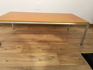 Mesa de cristal naranja con patas metálicas