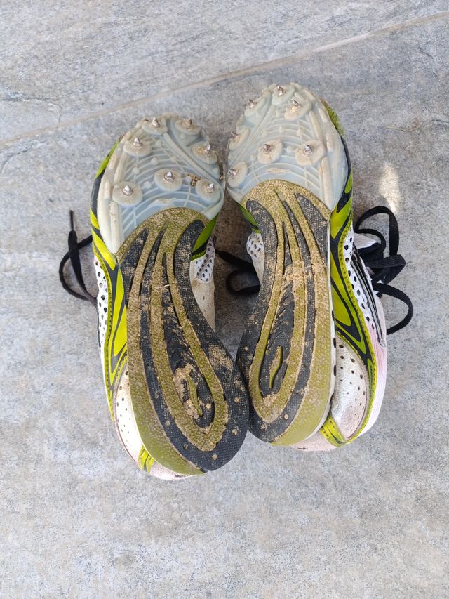 Zapatillas de clavos verdes y blancas