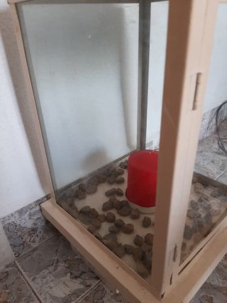 Farol decorativo beige con piedras y vela