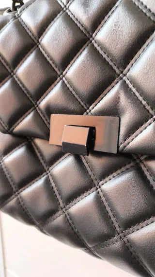 Bolso negro acolchado con cadena metálica