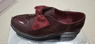 Mocasines rojos con lazo y detalles plateados
