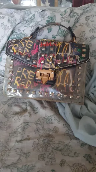 Bolso de mano con tachuelas y graffiti