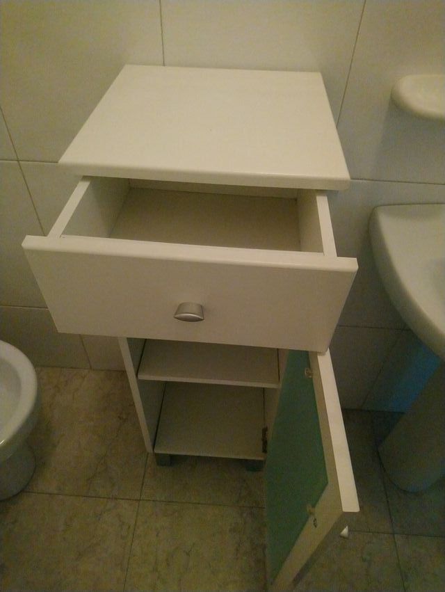 Mueble de baño blanco con puerta de cristal
