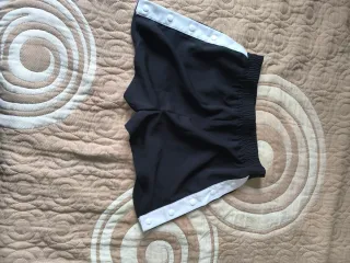 Pantalones cortos negros con botones blancos
