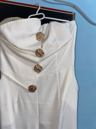 Mono blanco elegante con botones dorados