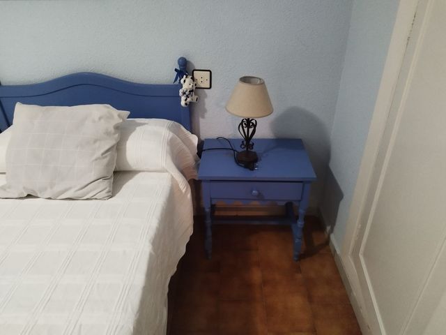 Mesita de noche azul de madera y dos colchones.