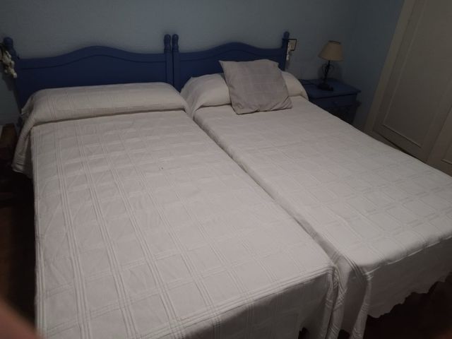 Mesita de noche azul de madera y dos colchones.