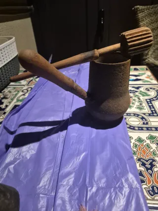Tetera antigua de metal con mango de madera