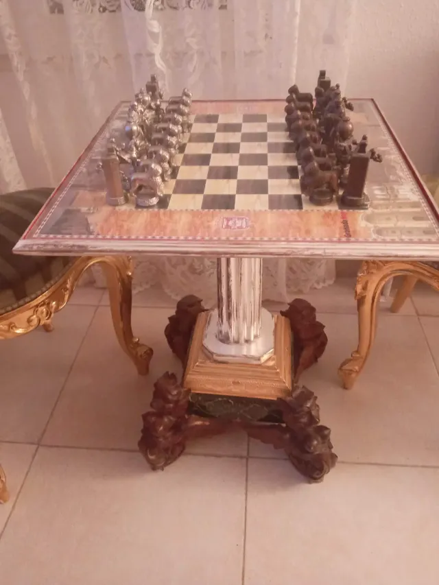 Juego de ajedrez antiguo con sillas y mesa doradas