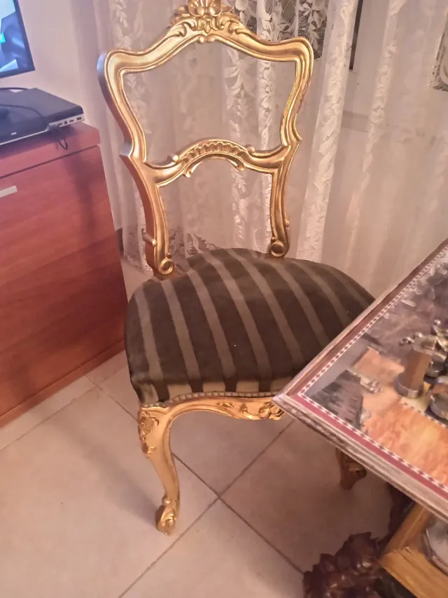 Juego de ajedrez antiguo con sillas y mesa doradas