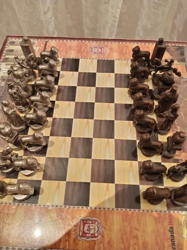 Juego de ajedrez antiguo con sillas y mesa doradas