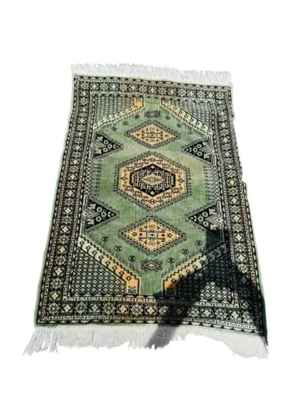 Tappeto orientale verde con motivi geometrici