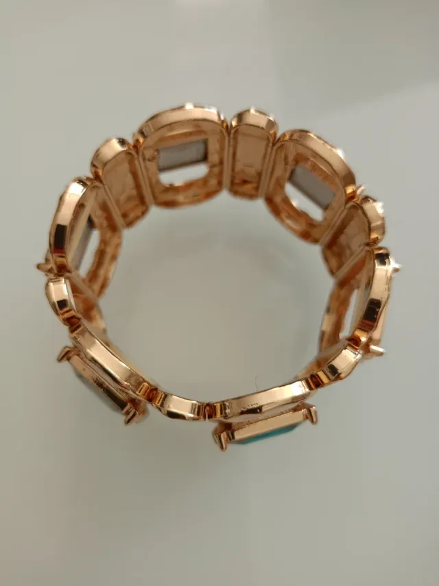 Pulsera dorada con piedras moradas y verdes