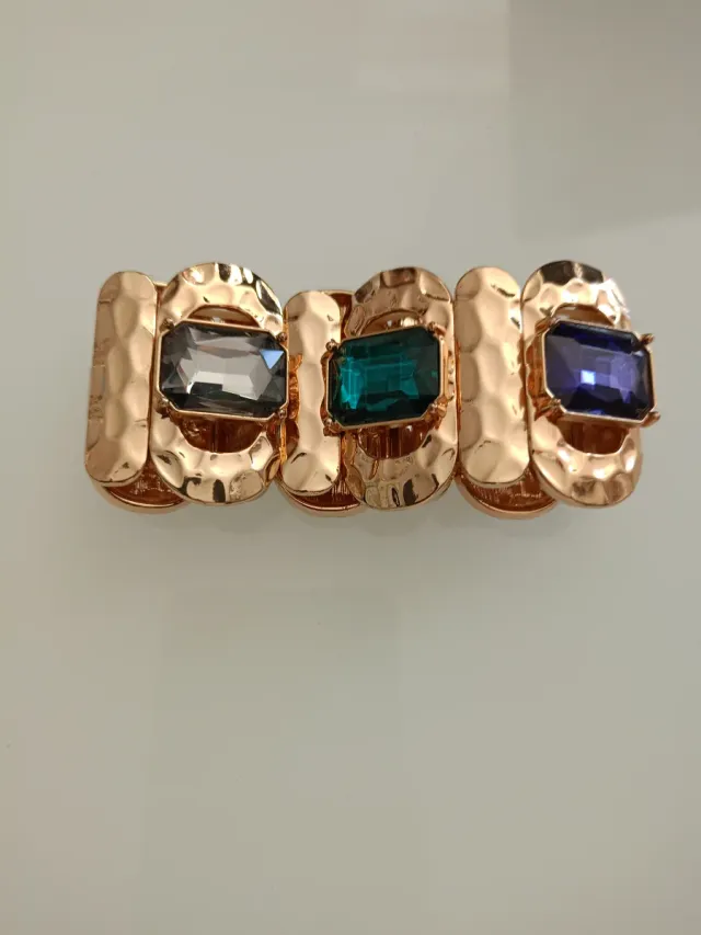 Pulsera dorada con piedras moradas y verdes