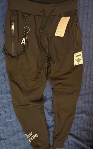 Pantalón negro con cremalleras y cadena