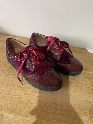 Zapatos rojos con tachuelas plateadas