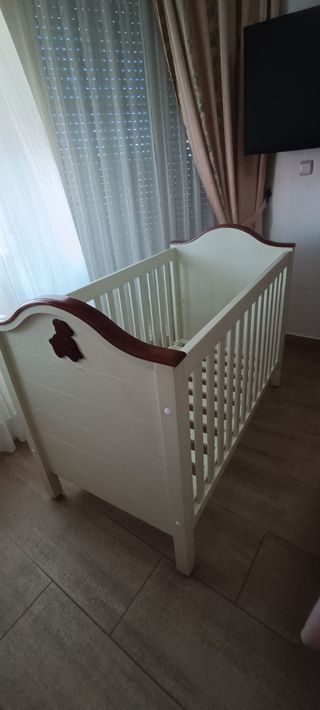 Cuna de madera blanca con detalles en marrón 