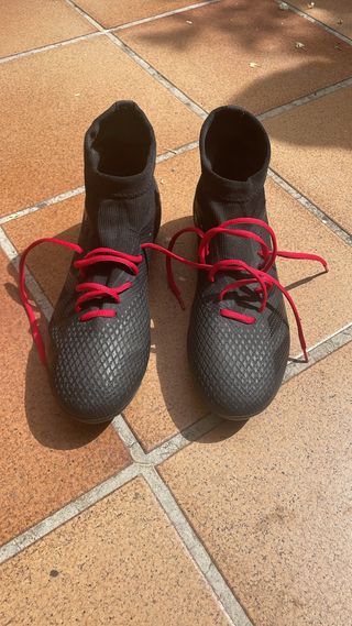 Botas de fútbol negras con cordones rojos