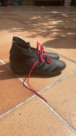 Botas de fútbol negras con cordones rojos