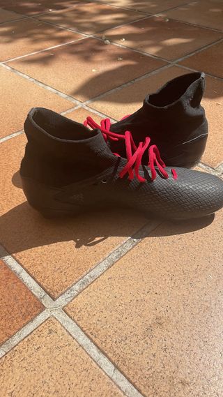 Botas de fútbol negras con cordones rojos