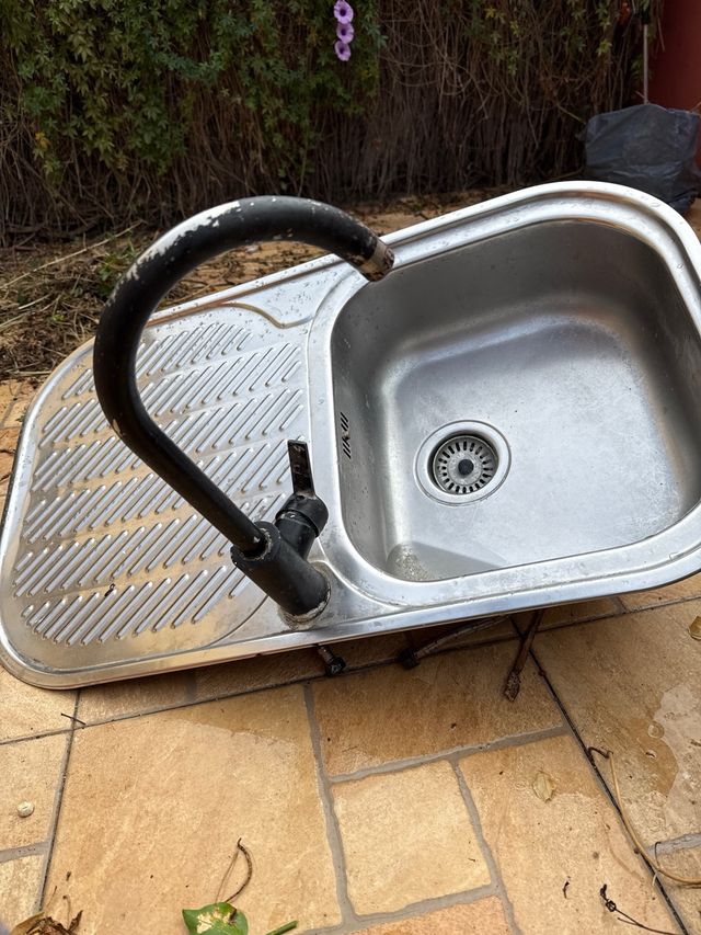 Fregadero de cocina metálico con escurridor