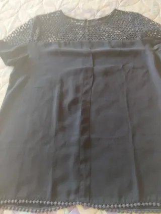 Blusa  con encaje y borlitas abajo.