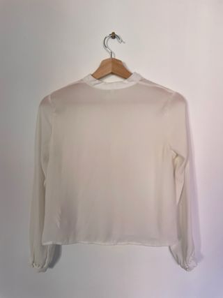 Blusa blanca semitransparente con lazo en cuello